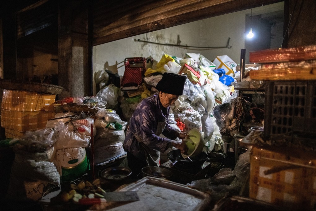 An elderly woman washes dishes next to a place where she lives, at a market in Ganluo County, Sichuan Province. Sichuan province is considered one of China’s most poverty-stricken areas. Photo: EPA-EFE