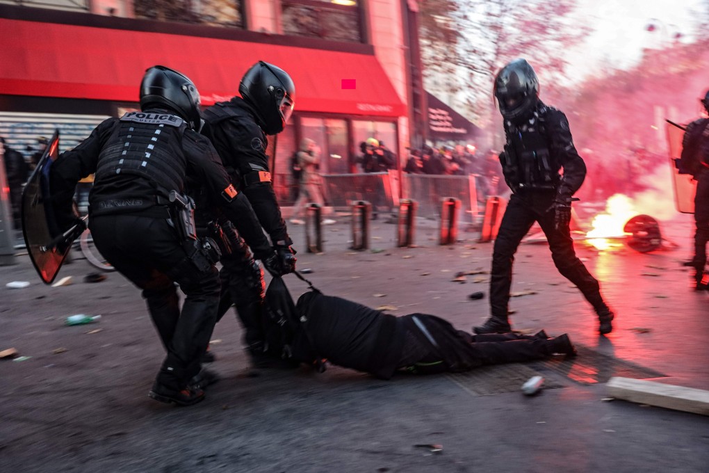 Police officers drag a man on the ground during a protest against France’s draft security law on Saturday. Photo: AFP