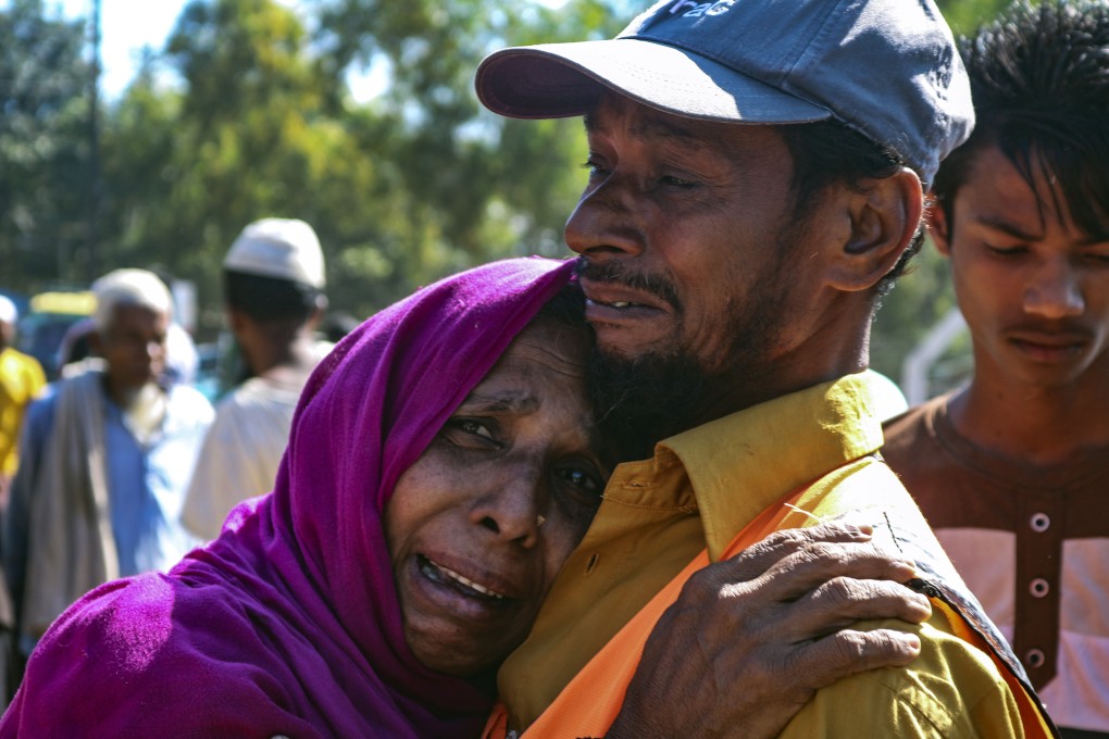 A Rohingya refugee woman and man who are among those being moved to Bhasan Char island cry as they stand outside a transit area where they are temporally housed in Ukhiya, Bangladesh. Photo: AP