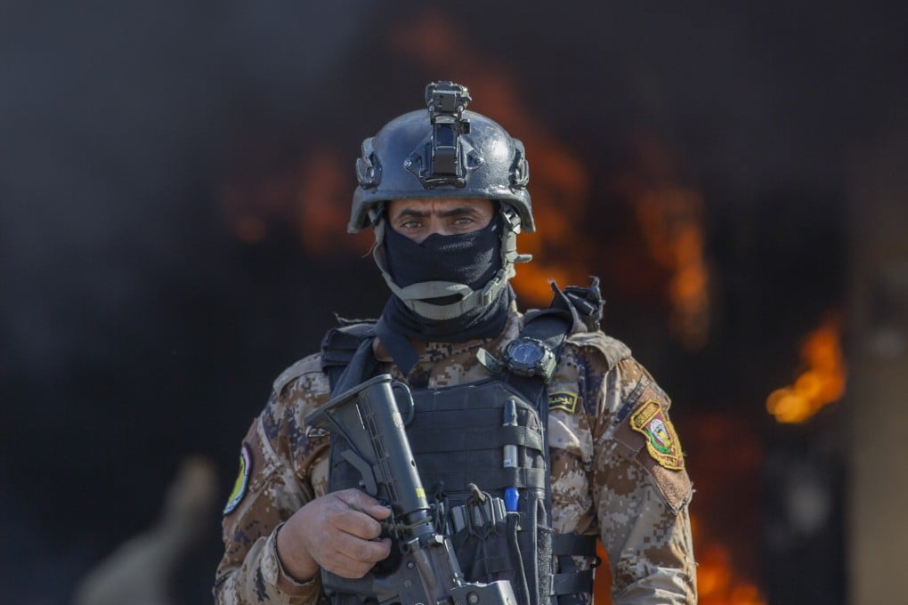An Iraqi soldier stands guard in front of a fire set by pro-Iranian militiamen and their supporters in the US embassy compound in Baghdad in January. Photo: AP