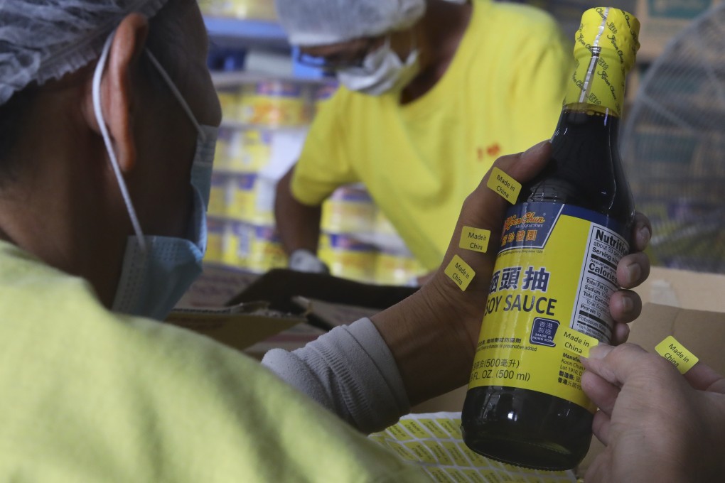 Workers at Koon Chun Hing Kee Soy & Sauce Factory in Yuen Long add “Made in China” labels to products to be exported to the US. Photo: Dickson Lee