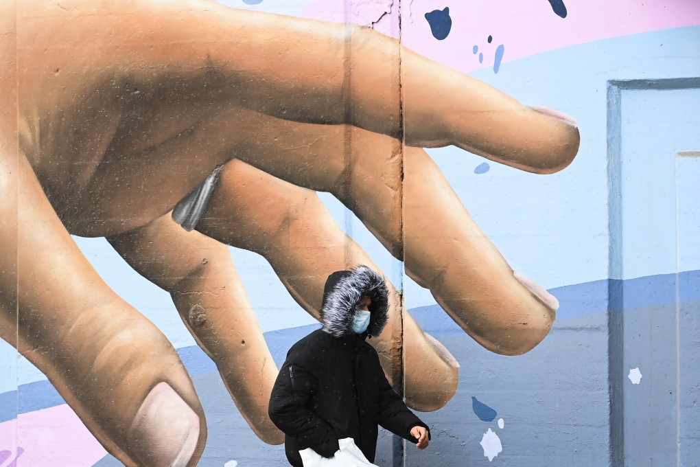 A man wearing a face mask walks past a mural in Toronto on Tuesday. Photo: The Canadian Press via AP