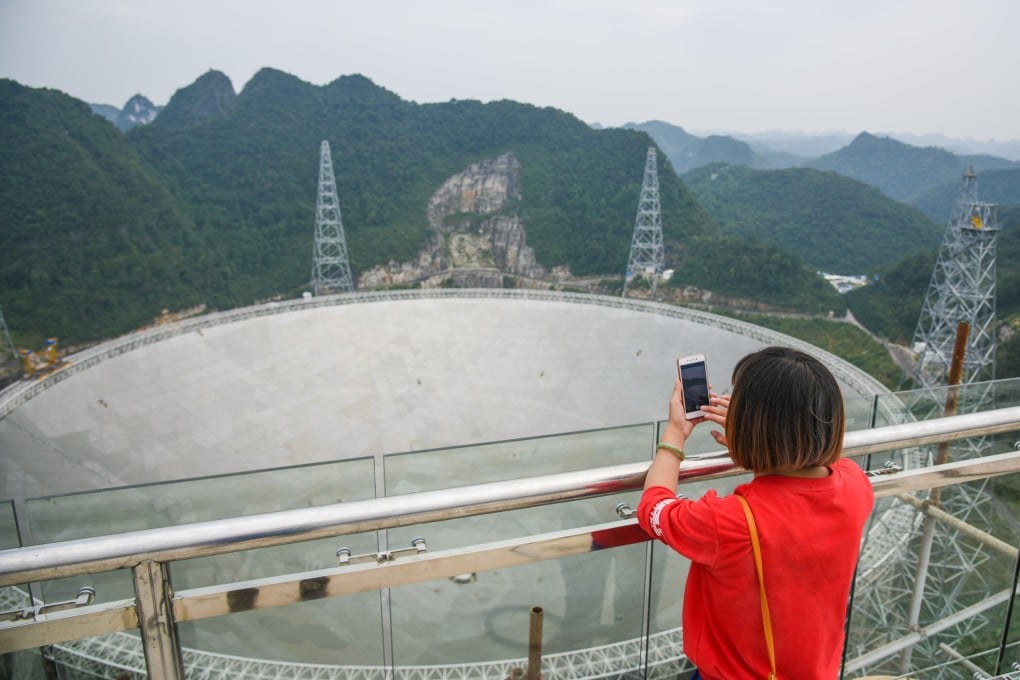 A woman takes photos of the Five-hundred-metre Aperture Spherical Telescope, also known as FAST. The world’s largest full dish radio telescope is located in Pingtang County, in southwest China’s Guizhou province. Photo: Xinhua