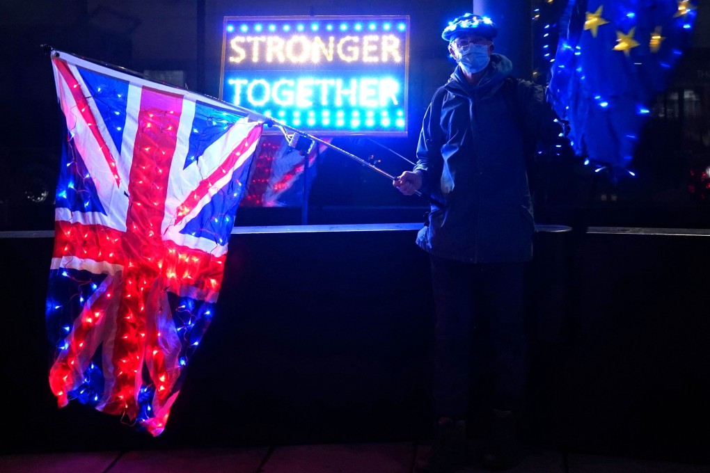 An anti-Brexit protester stands with UK and EU flags outside a conference centre in central London on Friday. Photo: AFP
