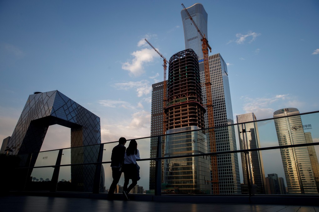 Two people look out at the skyline of the Central Business District in Beijing, on April 16. China is moving firmly and clearly ahead of its rivals, according to the latest OECD economic outlook. Photo: Reuters