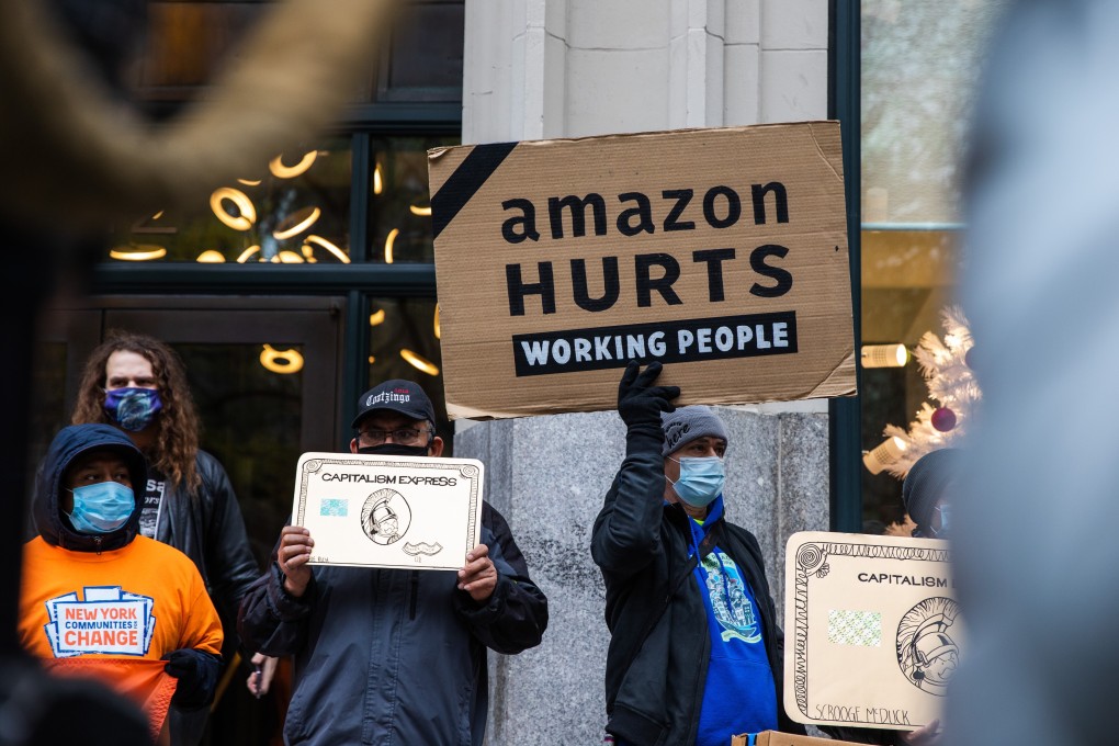 Demonstrators hold signs during a protest outside the home of Amazon chief executive Jeff Bezos in New York on Wednesday. Photo: Bloomberg