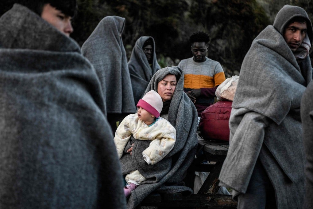 Migrants and refugees who arrived from Turkey to the Greek island of Lesbos huddling for warmth. Photo: AFP