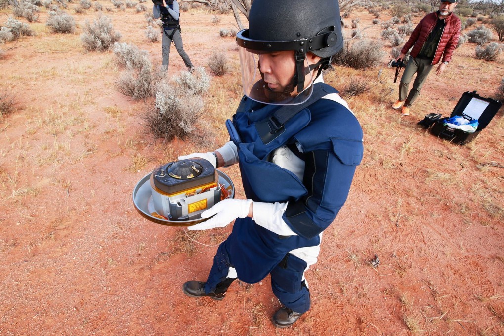 A member of the Japan Aerospace Exploration Agency (Jaxa) collects a capsule from Hayabusa2 carrying the first extensive samples of an asteroid, after it landed in Woomera, Australia on December 6. Photo: Reuters