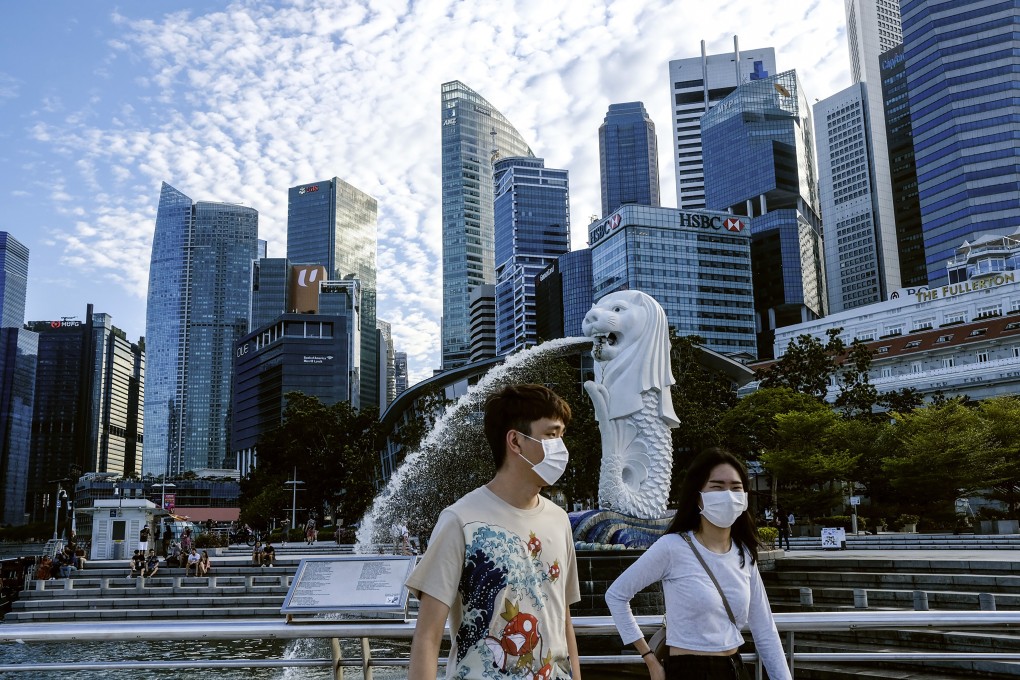 A couple wearing face masks pass the Merlion statue in Singapore. Photo: AP