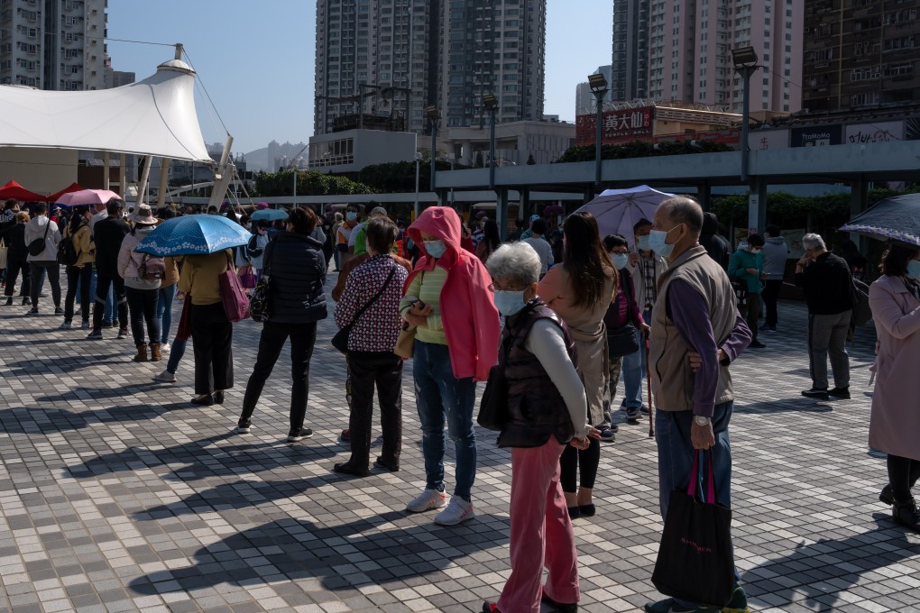 People wearing protective masks maintain social distancing while standing in line at a Community Testing Center in Hong Kong. Photo: Bloomberg