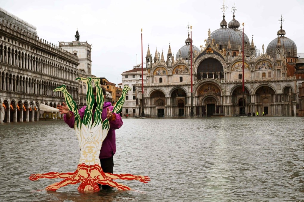 A man poses for a photo by a cardboard cut-out of the Vitruvian Man in Venice’s flooded St Mark’s Square on Tuesday. Photo: AFP