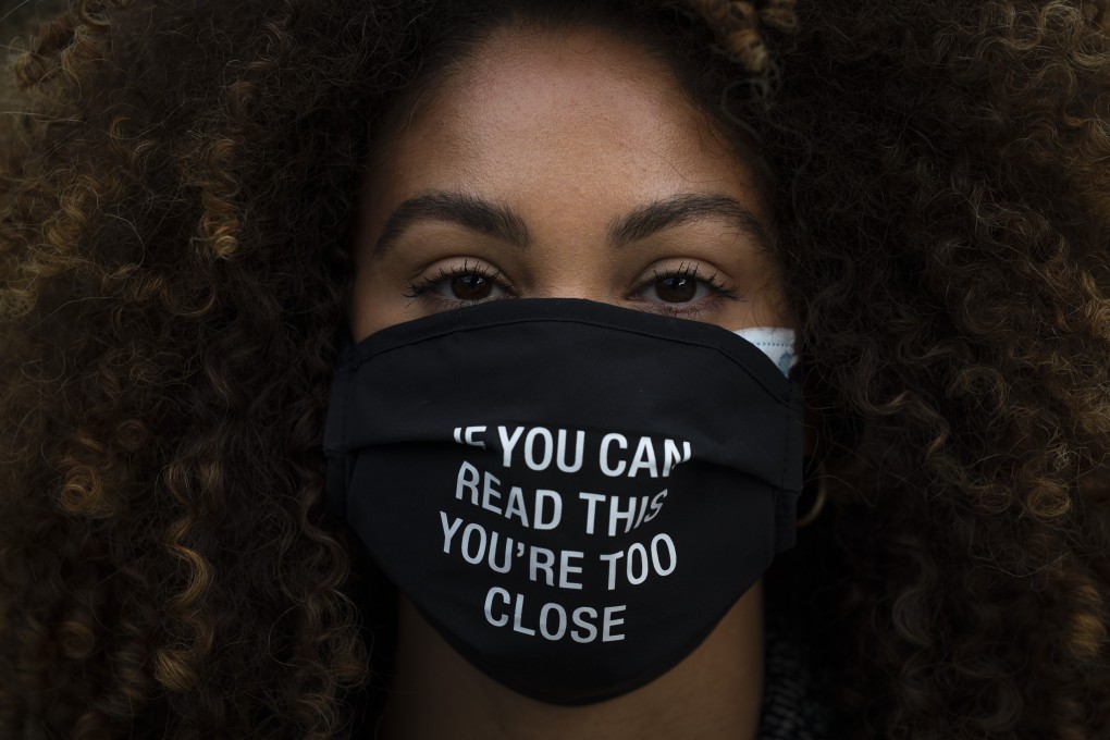A woman in Los Angeles wears a face mask with a message. Photo: AP