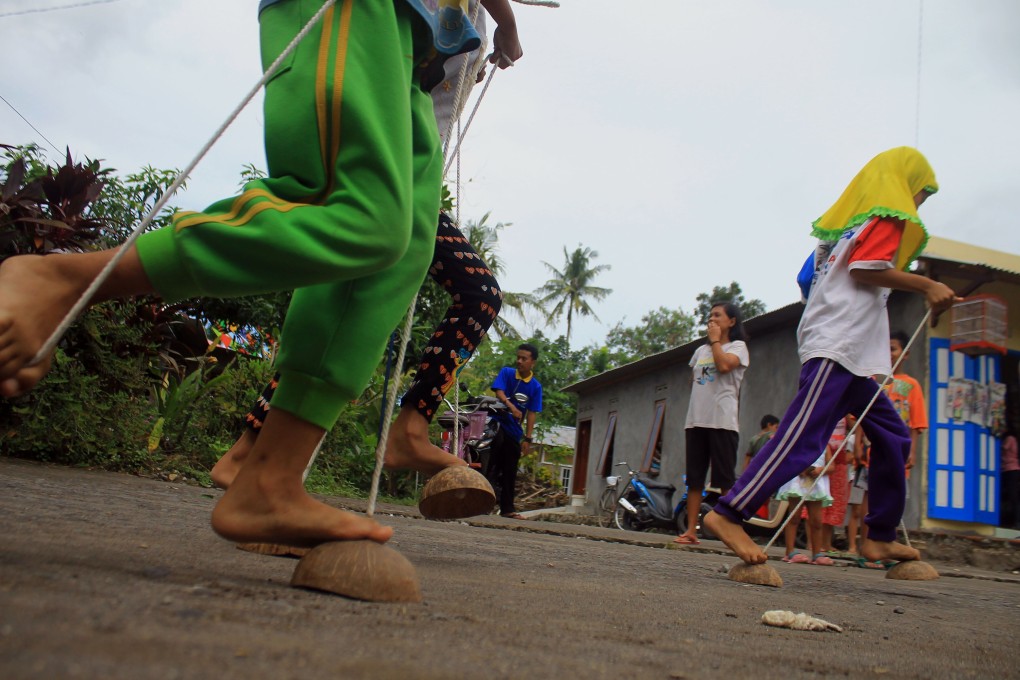 Traditional games and toys are having a revival in Indonesia. Egrang batok (above) uses coconut shells as mini stilts. Photo: Nugroho Hadi Santoso/NurPhoto via Getty Images