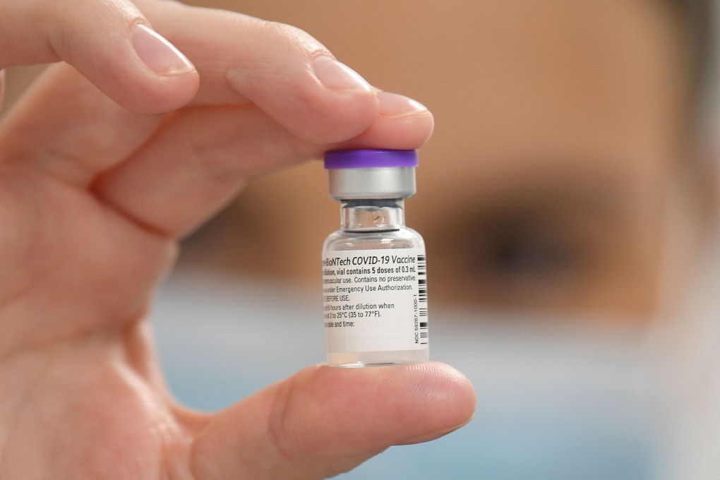 A member of staff poses with a phial of Pfizer-BioNTech Covid-19 vaccine at a health centre in Cardiff, South Wales on Tuesday. Photo: AFP