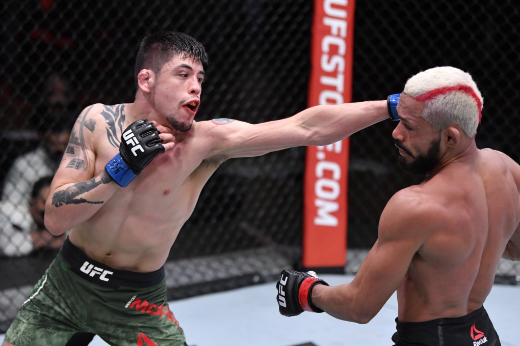 Brandon Moreno punches Deiveson Figueiredo in their flyweight championship bout during UFC 256. Photos: Jeff Bottari/Zuffa LLC