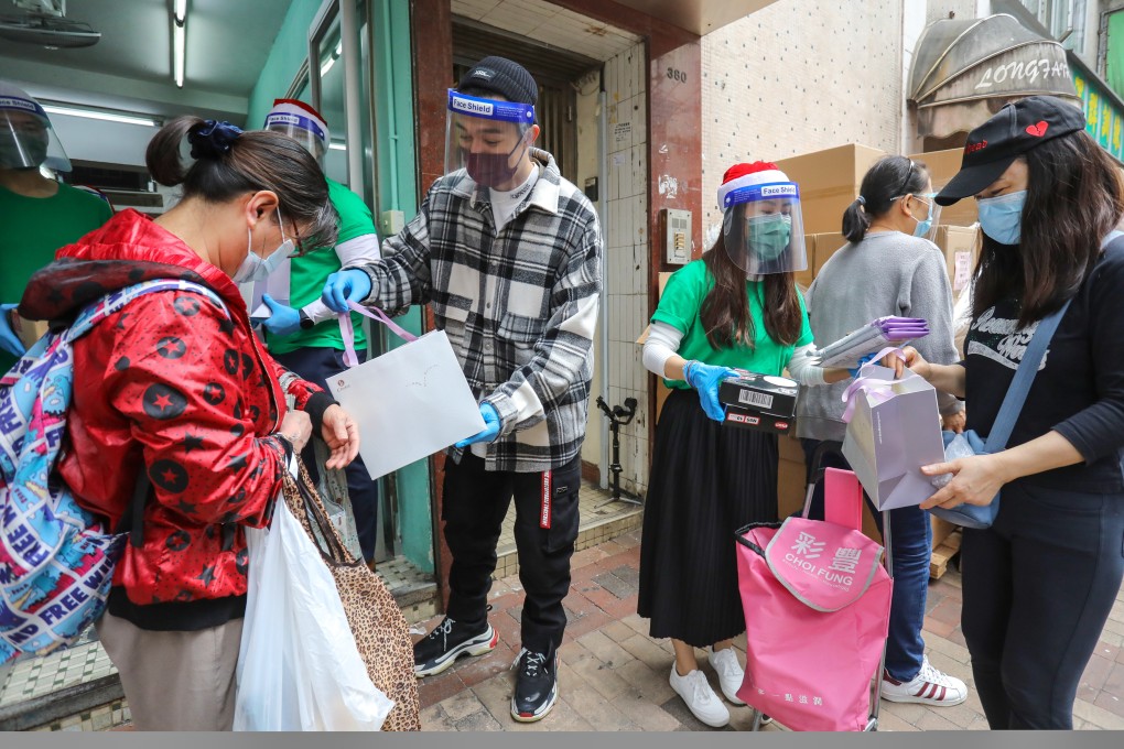 Operation Santa Claus ambassador Pakho Chau helps hand out supplies to Sham Shui Po residents last week. Photo: May Tse