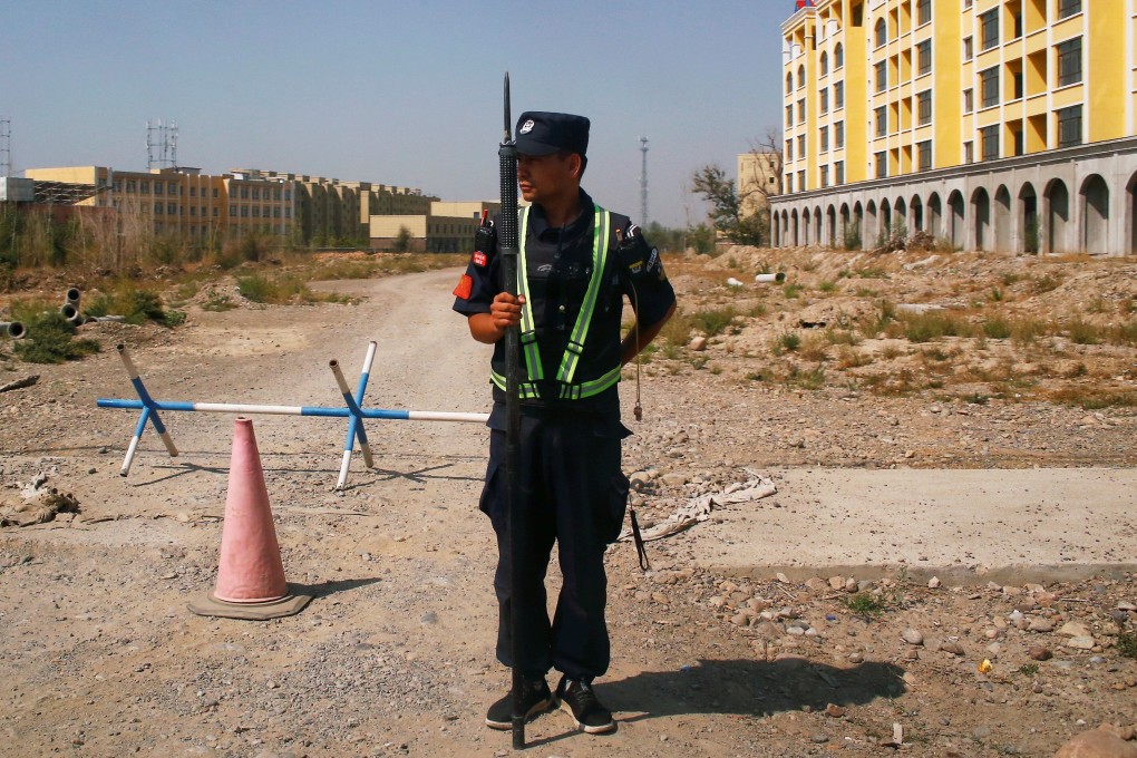 A Chinese police officer takes his position by the road near what is officially called a vocational education centre in Xinjiang in September 2018. Photo: Reuters