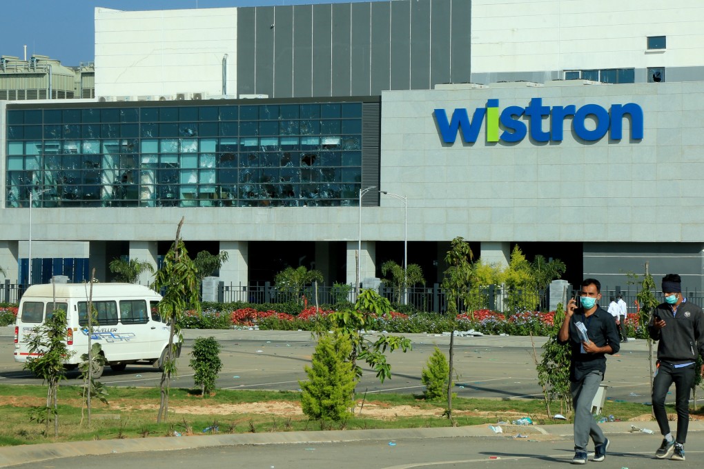 People walk outside the iPhone manufacturing facility trashed over the weekend by workers demanding better wages and conditions. Photo: Reuters