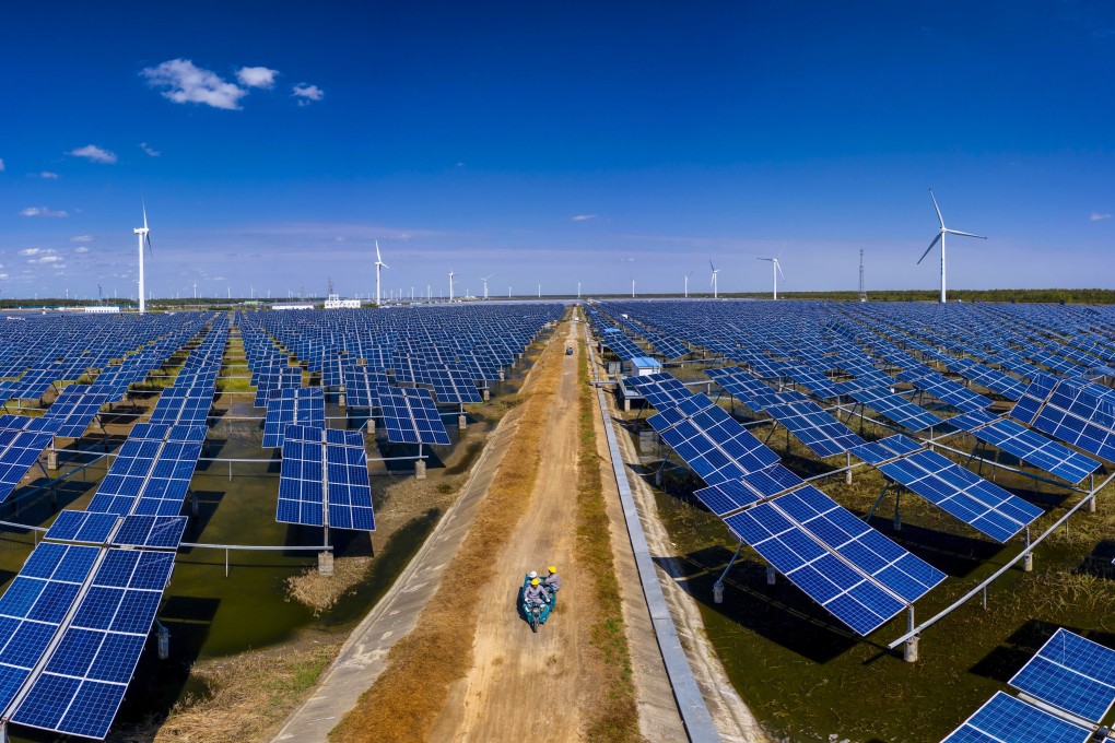 Maintenance workers drive between solar panels and wind turbines in Dongtai, Jiangsu province, China, on October 14. China’s pledge to be carbon neutral by 2060 means that boosting renewable energy use will be a priority. Photo: EPA-EFE
