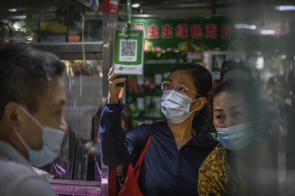 A young woman uses her mobile phone to scan a QR code in order to make a payment with the WeChat app at a market in Beijing. Elderly people in China are having to learn about mobile payments, scanning QR codes to enter shops and banks, and more in the aftermath of Covid-19. Photo: Kevin Frayer/Getty Images
