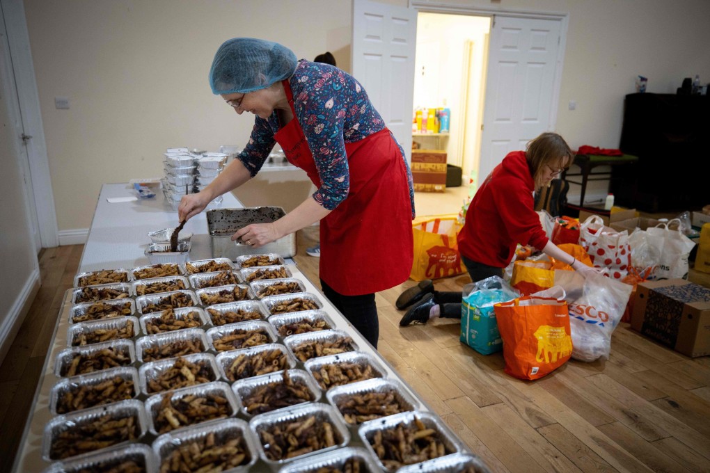 A member of staff prepares boxes of pasta for vulnerable families, at the Cooking Champions food bank in Grange Park, north London. Photo: AFP