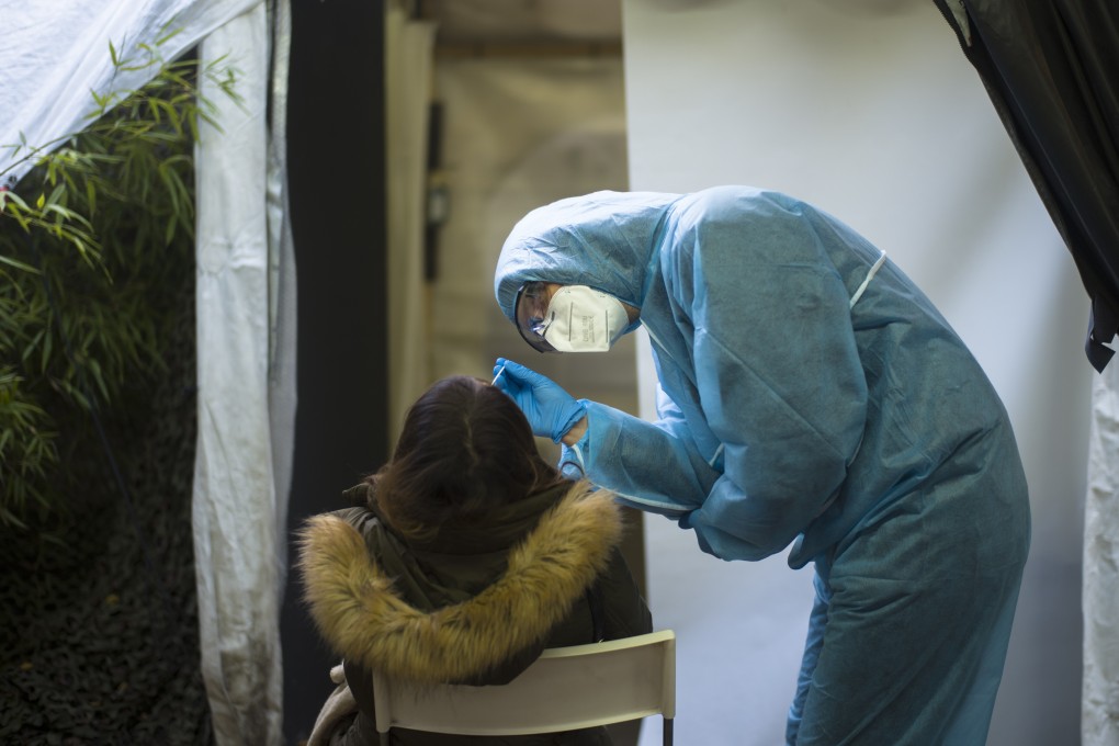 A health worker takes swab samples from a man at a Covid-19 testing centre in Berlin, Germany. Photo: AP