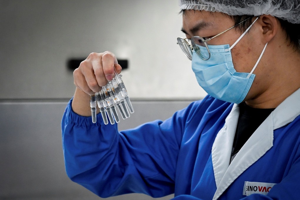 A Sinovac employee checks Covid-19 vaccines during a media tour in September of a new factory built in Beijing to produce the vaccines. Hong Kong has announced procurement agreements with three pharmaceutical companies, including Sinovac. Photo: AFP