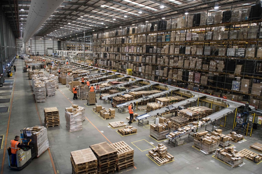 Workers prepare customer orders for dispatch as they work around goods stored inside an Amazon fulfilment centre in Peterborough, central England, on November 15, 2017. Photo: AFP