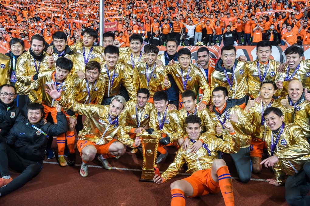 Shandong Luneng players and staff celebrate with the Chinese FA Cup trophy. Photo: Xinhua