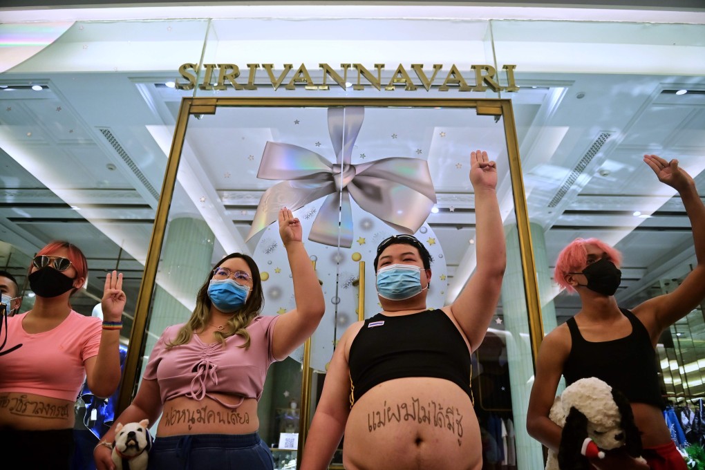 Pro-democracy activists led by Parit “Penguin” Chiwarak, second from right, give the three-finger salute during an antimonarchy demonstration at Siam Paragon shopping centre. Photo: AFP