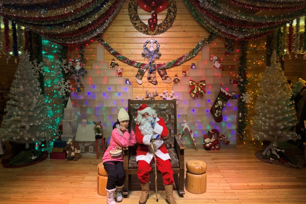A visitor poses with Santa, played by Ville Haapassallo from Finland, near Mohe in China. Photo: Reuters