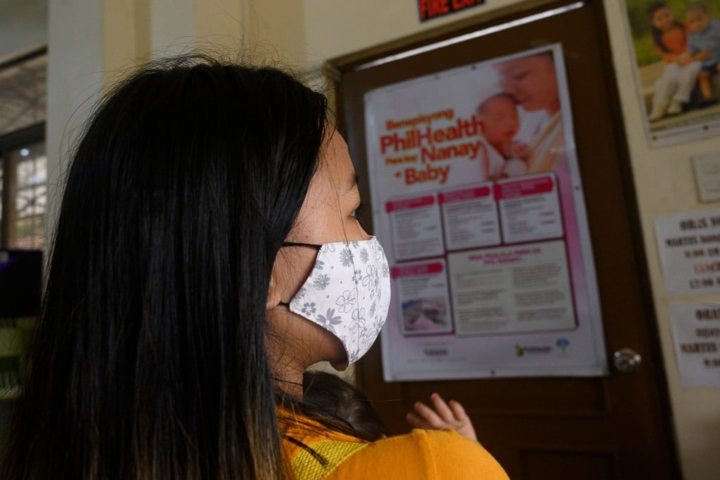 Donna Valdez, 15, carries her child at a health centre in Manila. Photo: AFP