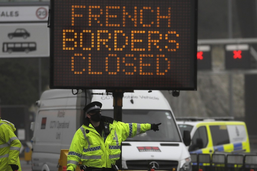 A police officer directs traffic at the closed ferry terminal in Dover, England. More than 30 countries and regions have now suspended travel with Britain because of a new strain of the coronavirus. Photo: AP