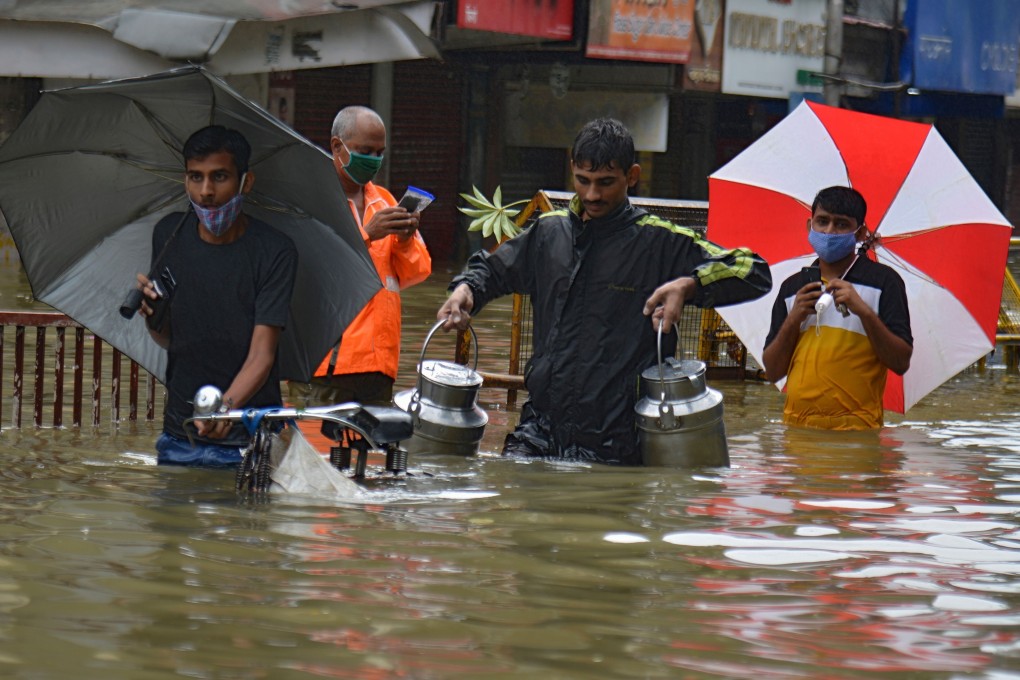 People wade through a flooded street following heavy monsoon rains in Mumbai on September 23. Photo: AFP