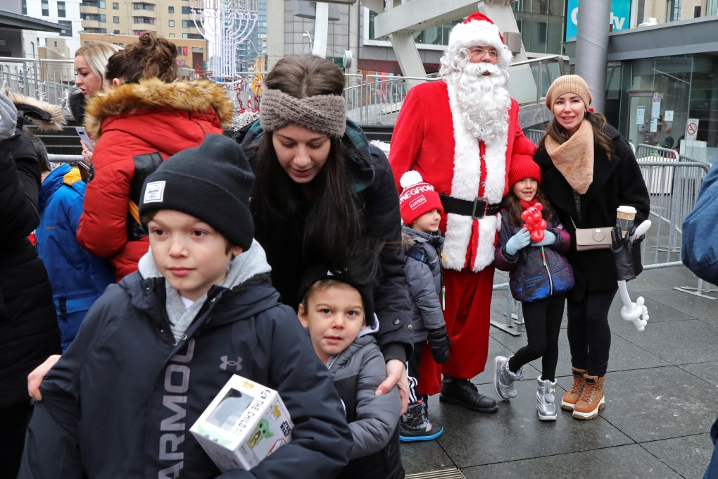 A maskless Santa Claus poses with children from a group protesting against coronavirus restrictions in Toronto, Canada. Photo: Reuters