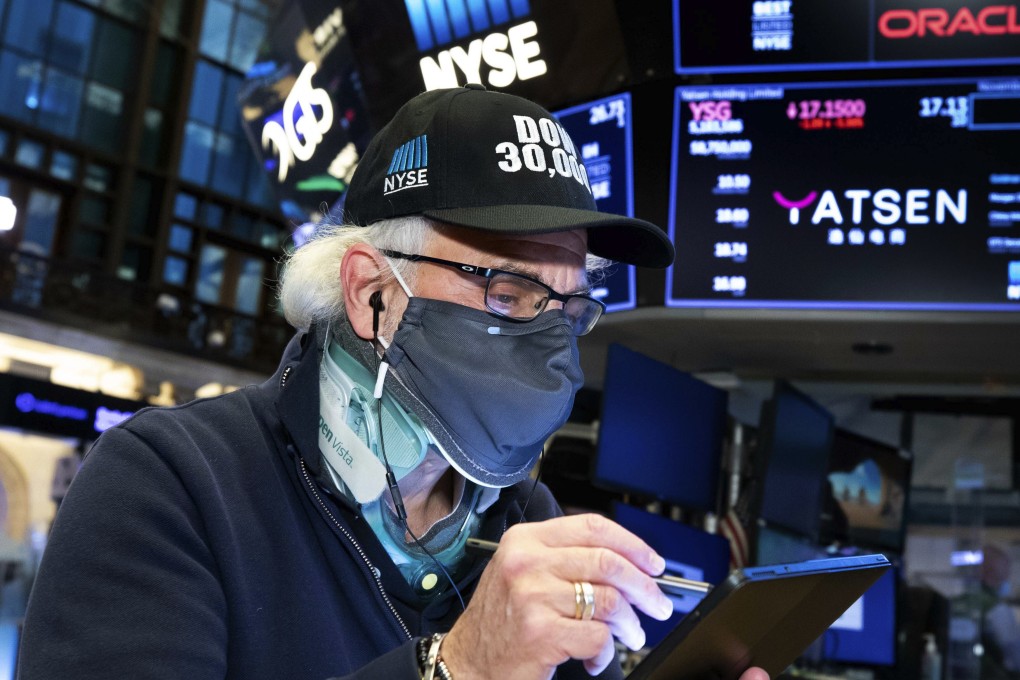 Trader Peter Tuchman wears a “Dow 30,000” hat as he works on the trading floor on November 24, when the Dow Jones Industrial Average closed above 30,000 points for the first time as progress in the development of coronavirus vaccines and news that the transition of power in the US to President-elect Joe Biden will finally begin kept investors in a buying mood. Photo: New York Stock Exchange via AP