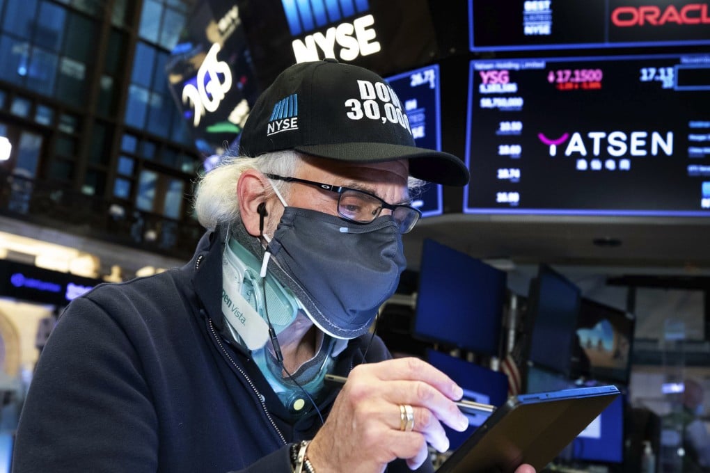 Trader Peter Tuchman wears a “Dow 30,000” hat as he works on the trading floor on November 24, when the Dow Jones Industrial Average closed above 30,000 points for the first time as progress in the development of coronavirus vaccines and news that the transition of power in the US to President-elect Joe Biden will finally begin kept investors in a buying mood. Photo: New York Stock Exchange via AP