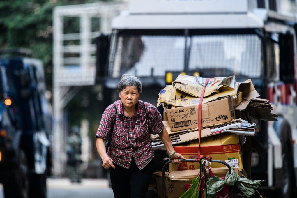 An elderly woman drags a trolley load of cardboard for recycling in Hong Kong. Photo: AFP