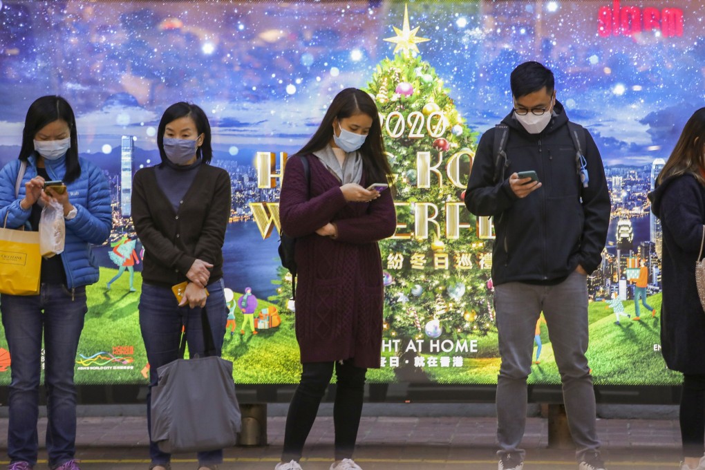Hong Kong commuters wait for a bus in Central on December 15, during the closing days of a year dominated by the coronavirus pandemic and tightening state controls. Photo: Martin Chan