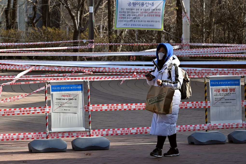 A woman walks past a park closed to prevent spread of the Covid-19 in Seoul. Photo: AFP