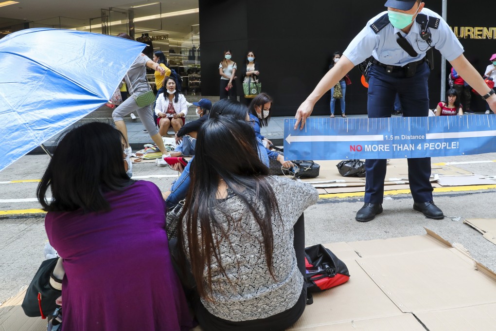 A policeman asks domestic workers to disperse as they gather in Central. Photo: Edmond So