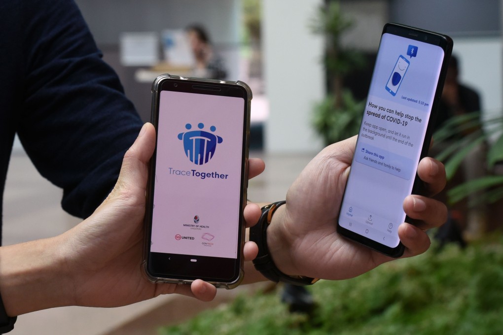 Staff members of Singapore’s Government Technology Agency show off the country’s contact-tracing smartphone app, TraceTogether. Photo: AFP