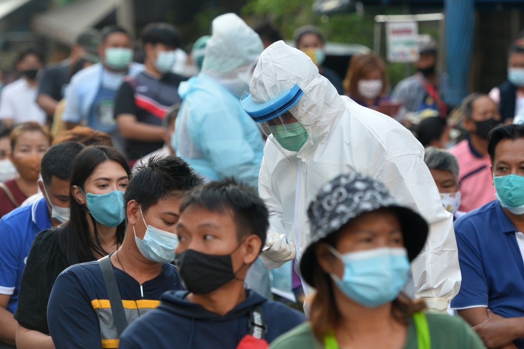 People wait to receive Covid-19 tests in Samut Sakhon province. Photo: Xinhua