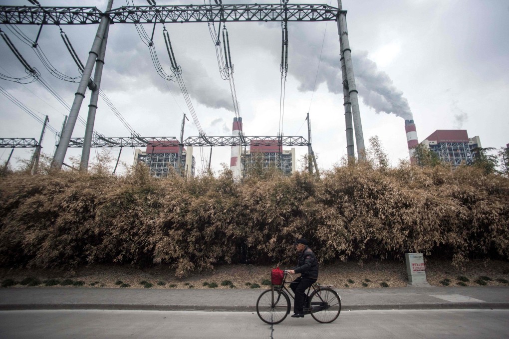 A man cycles past the Waigaoqiao Power Generator Company coal power plant in Shanghai. Even with China’s heightened pledges on reducing greenhouse gas emissions and the prospect of the US rejoining the Paris climate agreement, greater US-China cooperation is essential to addressing climate change before it is too late. Photo: AFP