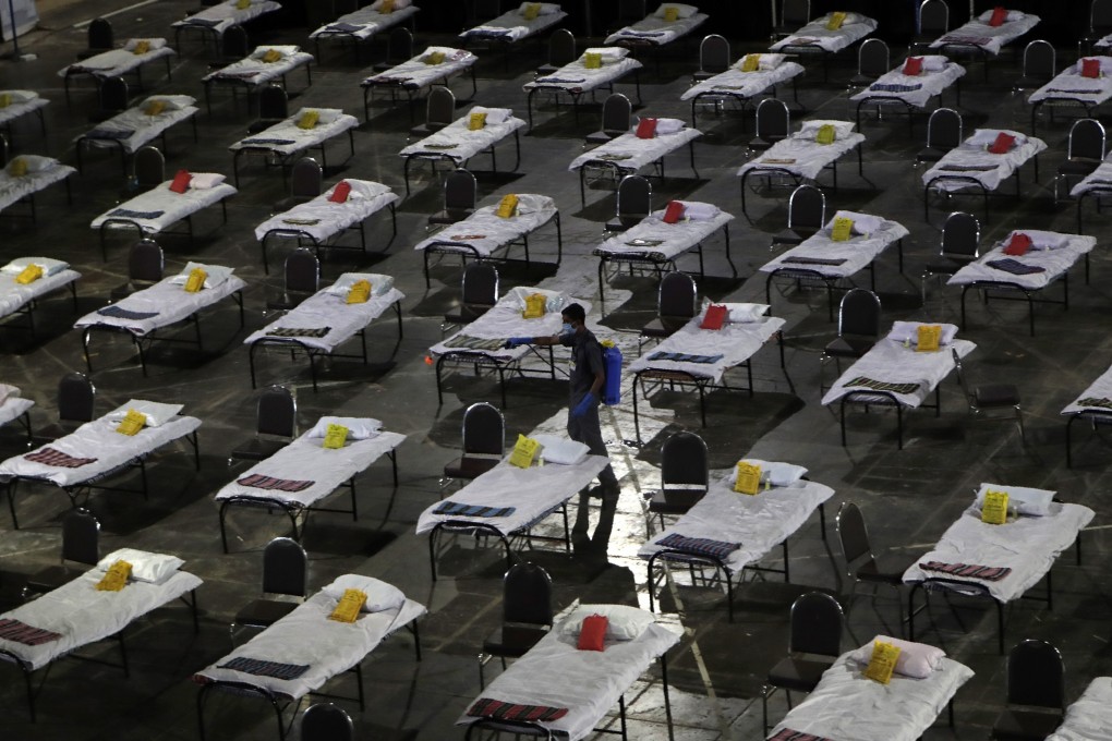 A civic worker sprays disinfectant on beds at a special temporary hospital facility for Covid-19 patients in Mumbai, India, on April 10. Photo: AP