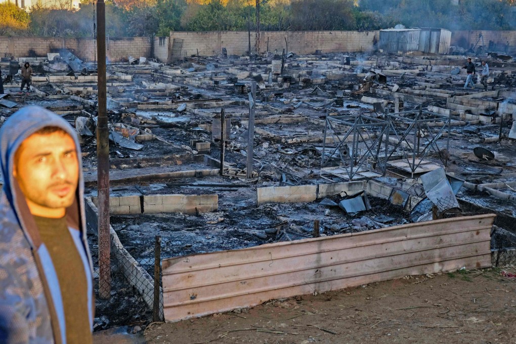 Syrian refugees salvage belongings from the wreckage of their shelters at a camp set on fire in the northern Lebanese town of Bhanine. Photo: AFP