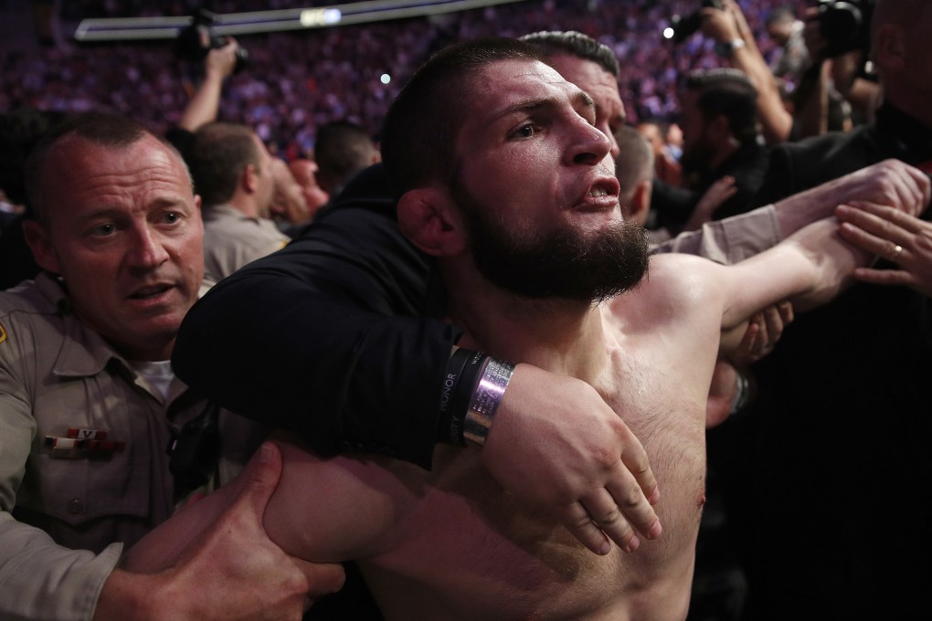 Khabib Nurmagomedov is held back outside the cage after fighting Conor McGregor in a lightweight title bout at UFC 229. Photo: AP