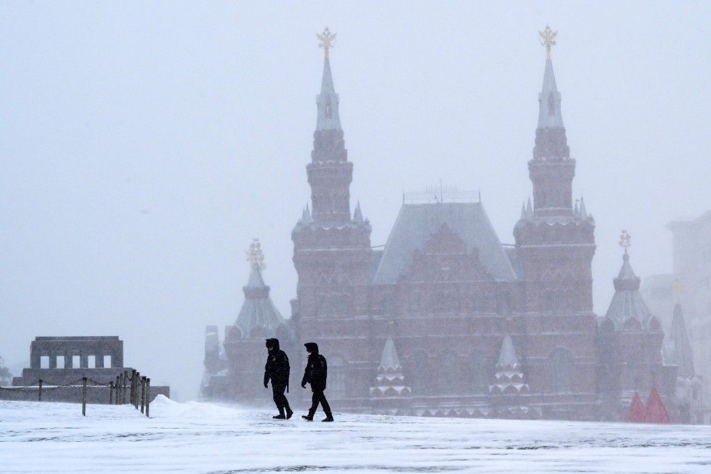 Policemen wearing face masks walk on snow-covered Red Square in downtown Moscow on Friday. Photo: AFP