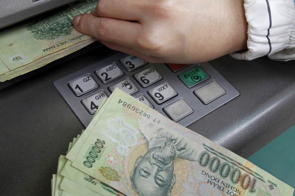 A woman withdraws money from an ATM in Hanoi in February 2011. Photo: Reuters