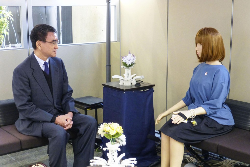 Taro Kono, the Japanese minister in charge of administrative reform, talks to an AI-equipped humanoid robot on December 20, during a visit to the Advanced Telecommunications Research Institute International in Seika, Kyoto. Photo: Kyodo